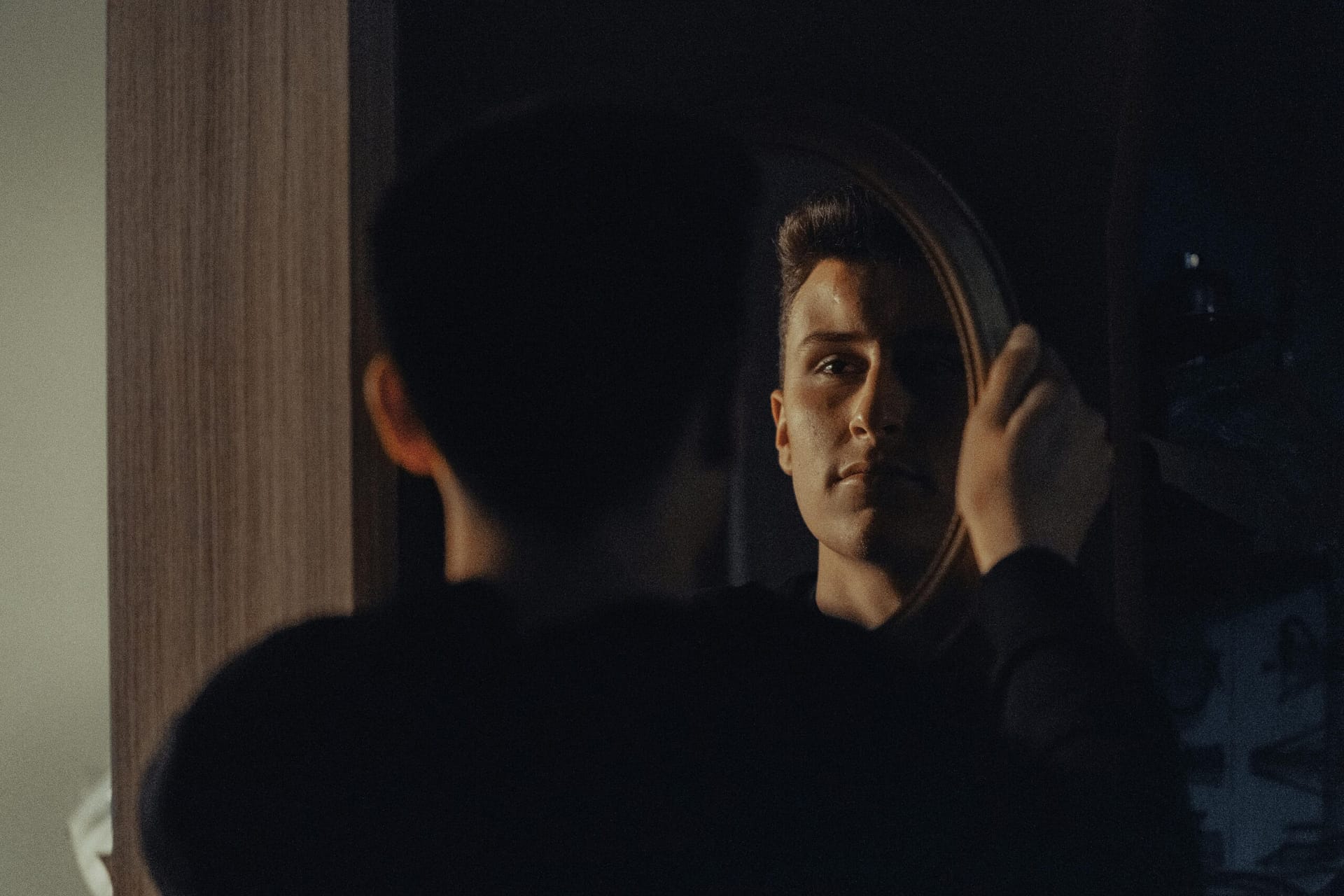 How to stop overthinking - A man gazing at his reflection, capturing an introspective moment indoors.
